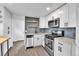 Updated kitchen with stainless steel appliances, granite countertops, white cabinets, and subway tile backsplash at 1000 S Perry St, Denver, CO 80219