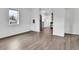 Open-concept living room showcasing new flooring and a glimpse into the modern kitchen with stainless steel appliances at 1000 S Perry St, Denver, CO 80219