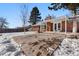 Brick home with backyard patio and snow covered yard at 420 Racine St, Aurora, CO 80011