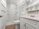 Bathroom with shower/tub combo, white vanity, and built-in shelves at 420 Racine St, Aurora, CO 80011