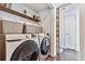 Convenient laundry room boasts modern washer and dryer, storage baskets, and wood-look flooring at 3383 Willowrun Dr, Castle Rock, CO 80109