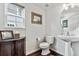 Charming powder room features a pedestal sink, toilet, framed art, and wood-look flooring at 3383 Willowrun Dr, Castle Rock, CO 80109