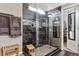 Stylish bathroom featuring glass enclosed shower with dark tile, bench, and built-in shelving at 3383 Willowrun Dr, Castle Rock, CO 80109