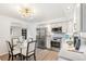 Eat-in kitchen showcases stainless steel appliances, white cabinets, and modern lighting at 1772 S Pierce St, Lakewood, CO 80232