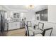 Modern eat-in kitchen featuring stainless steel appliances, quartz countertops, and stylish light fixture at 1772 S Pierce St, Lakewood, CO 80232