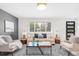 Sunlit living room features a cozy seating area, stylish decor, and views of the front yard at 1772 S Pierce St, Lakewood, CO 80232