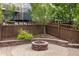 Backyard brick patio with a built-in fire pit and privacy fence at 2828 Shadow Dance Dr, Castle Rock, CO 80109