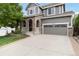 Charming two-story home featuring a brick facade, covered porch and manicured lawn, showcasing curb appeal at 2828 Shadow Dance Dr, Castle Rock, CO 80109