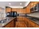 Well-lit kitchen featuring wood cabinets, granite countertops, and modern black appliances, offering ample counter space at 2828 Shadow Dance Dr, Castle Rock, CO 80109