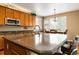 Kitchen island and eat-in kitchen with wood cabinets, granite countertops, and natural light from large windows at 2828 Shadow Dance Dr, Castle Rock, CO 80109