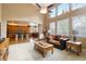Bright living room with large windows, hardwood floors, ceiling fan, and open floor plan with sight lines to the kitchen at 2828 Shadow Dance Dr, Castle Rock, CO 80109
