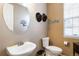 Neutral powder room with round mirror, hats hanging on the wall, and tiled floor at 2828 Shadow Dance Dr, Castle Rock, CO 80109