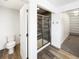 Modern bathroom showcasing tiled shower with glass door, complemented by stylish wood-look flooring at 4742 Quandary Peak St, Brighton, CO 80601