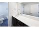 Bathroom boasting a sleek vanity with dark wood cabinets, white countertop, and large mirror at 4742 Quandary Peak St, Brighton, CO 80601