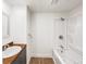 Bathroom with white tub and shower, wood countertop vanity, and laminate floors at 4742 Quandary Peak St, Brighton, CO 80601