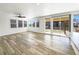 Sun-filled living room with luxury vinyl plank flooring, windows, and sliding doors at 4742 Quandary Peak St, Brighton, CO 80601