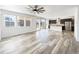 Open-concept living room with modern hardwood floors, large windows, and seamless flow to the kitchen at 4742 Quandary Peak St, Brighton, CO 80601