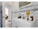 Bright bathroom with white tiling and a single sink vanity at 8110 Ivy St, Commerce City, CO 80022