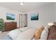 Well-lit bedroom featuring a large bed with colorful accents and two landscape paintings at 8110 Ivy St, Commerce City, CO 80022