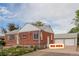 Cozy brick house with a detached garage and well-maintained landscaping at 8110 Ivy St, Commerce City, CO 80022