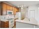 Bright kitchen with wooden cabinetry, white appliances, and a breakfast bar at 10259 W 55Th Dr # 103, Arvada, CO 80002
