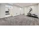 Finished basement space is carpeted and freshly painted with an elliptical and a TV at 6447 St Vrain Ranch Blvd, Longmont, CO 80504