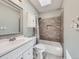 This bathroom features a vanity, toilet, and shower over tub with grey tile and niche at 6447 St Vrain Ranch Blvd, Longmont, CO 80504