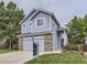 Charming two-story home featuring blue siding, brick accents, and a well-manicured front yard at 6447 St Vrain Ranch Blvd, Longmont, CO 80504