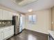 View of kitchen with stainless steel refrigerator, white cabinets, granite countertops and hardwood floors at 6447 St Vrain Ranch Blvd, Longmont, CO 80504