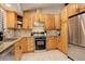 Cozy kitchen featuring light wood cabinets, granite countertops, stainless steel appliances, and wood floors at 6997 S Columbine Rd, Evergreen, CO 80439