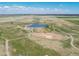 Aerial shot of a community pond surrounded by green fields and walking paths on a sunny day at 895 Antelope W Dr, Bennett, CO 80102