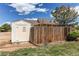View of the backyard featuring a shed, wooden fence, mature tree, and partial view of the house at 895 Antelope W Dr, Bennett, CO 80102