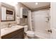 Bathroom featuring white shower stall, a dark vanity and wood-look tiled backsplash at 895 Antelope W Dr, Bennett, CO 80102