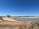Scenic view of community lake surrounded by open fields and new residential developments at 895 Antelope W Dr, Bennett, CO 80102
