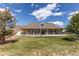 Spacious home featuring a grand, wrap-around porch and a well-manicured lawn creating an inviting curb appeal at 895 Antelope W Dr, Bennett, CO 80102