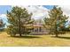 Charming yellow home with a covered porch, dormer windows, and a well-manicured lawn at 895 Antelope W Dr, Bennett, CO 80102