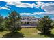 Charming yellow home with a covered porch, dormer windows, and a well-manicured lawn at 895 Antelope W Dr, Bennett, CO 80102