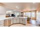 Open-concept kitchen with modern appliances, breakfast bar, and views into the living and dining areas at 895 Antelope W Dr, Bennett, CO 80102