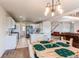 Well-designed kitchen with white cabinetry, stainless steel appliances, and a view of the dining area at 895 Antelope W Dr, Bennett, CO 80102