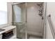 Modern tiled shower with glass door, rainfall shower head, and convenient grab bar at 895 Antelope W Dr, Bennett, CO 80102