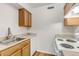 The bright kitchen features wood cabinets, a stainless steel sink, and white appliances at 3613 S Sheridan Blvd # 7, Denver, CO 80235