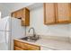 Bright kitchen features a stainless steel sink, wood cabinets, and ample counter space at 3613 S Sheridan Blvd # 7, Denver, CO 80235