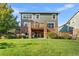 A large backyard with a deck and stairs made of wood and a stone exterior to the lower level patio at 6310 S Ider St, Aurora, CO 80016