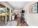 Basement gym with an elliptical and a home office area adjacent to a sliding glass door to the backyard at 6310 S Ider St, Aurora, CO 80016