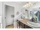 Bathroom featuring a double sink vanity, large mirror, and attached toilet room at 6310 S Ider St, Aurora, CO 80016