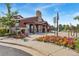 Charming clubhouse exterior, featuring stone accents, pergola, and vibrant floral landscaping at 6310 S Ider St, Aurora, CO 80016