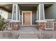 Inviting front porch with brick accents and contemporary design, featuring house number at 6310 S Ider St, Aurora, CO 80016