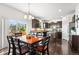 Open kitchen with a dining table and chairs, dark cabinetry, stainless appliances, and a sliding glass door at 6310 S Ider St, Aurora, CO 80016