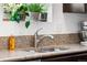 Close-up of a kitchen sink with granite countertops and a window with plants at 6310 S Ider St, Aurora, CO 80016
