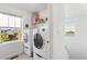 Bright laundry room featuring stacked washer and dryer units and a window view at 6310 S Ider St, Aurora, CO 80016
